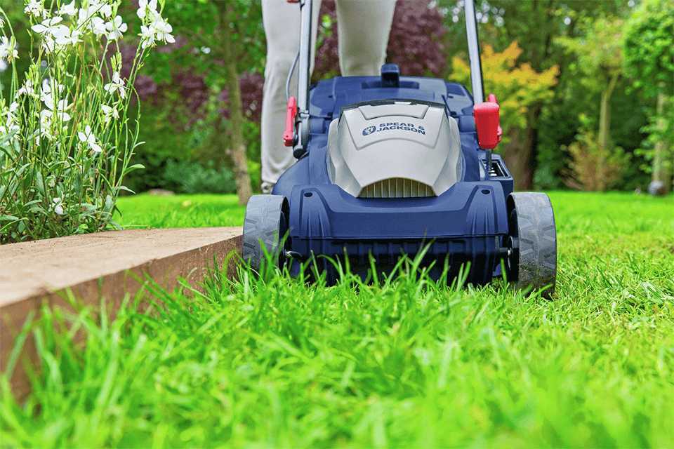A person using a lawnmower to mow a lawn.