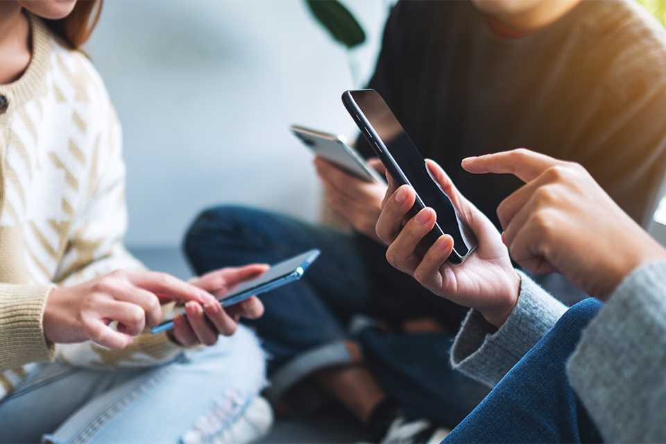 A group of people having a discussion over mobile phones.