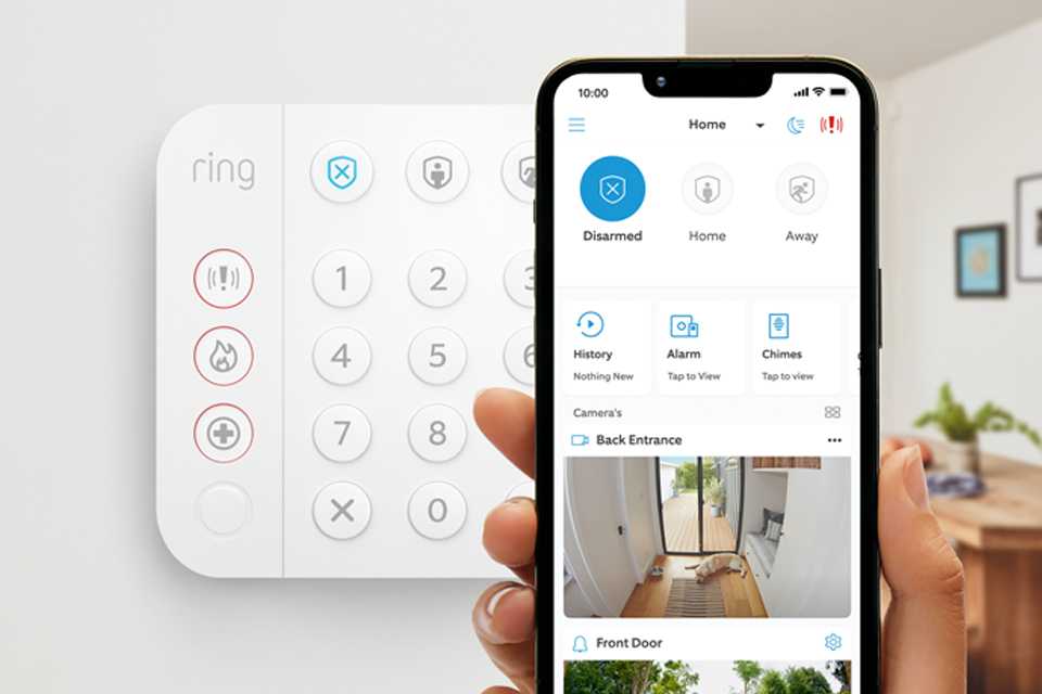 Person holding a phone with Ring app open in front of a Ring Alarm.