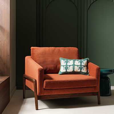 Habitat x Scion Esala Fabric Armchair in brown colour with a green cushion on it.