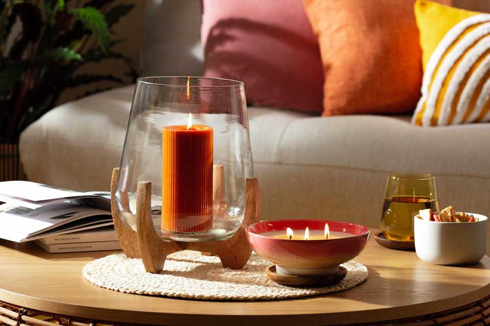 A Habitat Large lurricane candle holder with wooden legs.