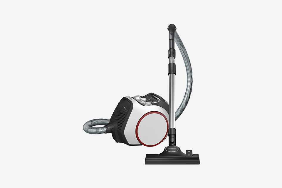 Miele Boost vacuum cleaner in white and red with hose stood up.