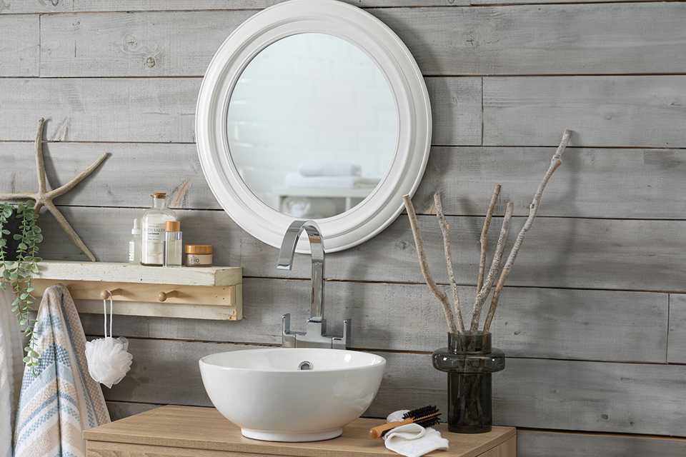 Innova round bathroom mirror in white over a sink.