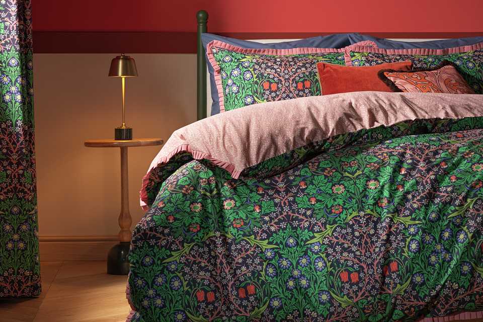 Floral green bedding with pink underside.