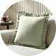 Sage green frill square cushion on accent chair .