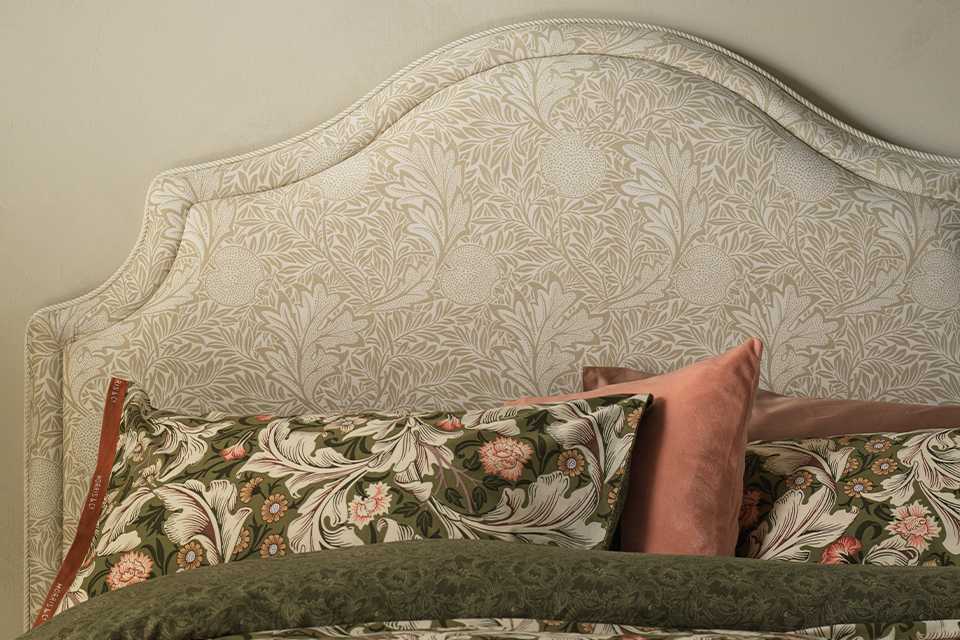 Morris and co habitat floral bedding and cushions on floral headboard.