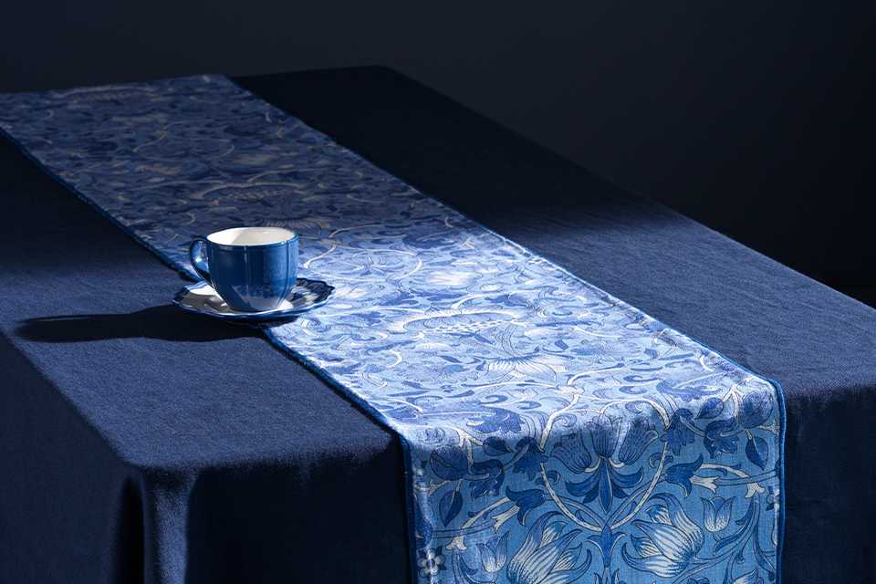 Blue dining room with Morris tablware in blue china floral print and blue tablecloth.