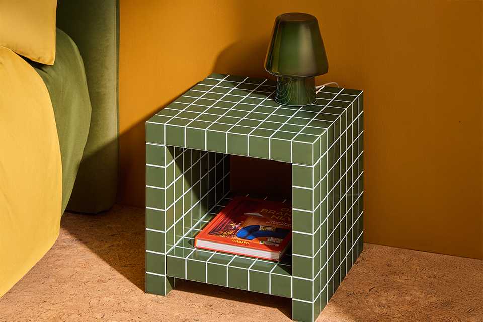 Green tile side table in bedroom with green mushroom lamp.
