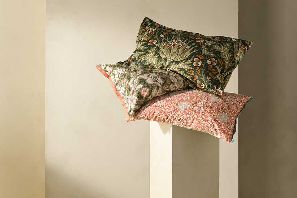 Morris and co habitat floral bedding and cushions on floral headboard.