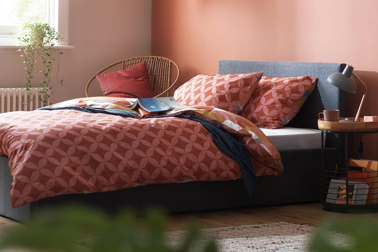 Orange diamond bedspread on double bed.
