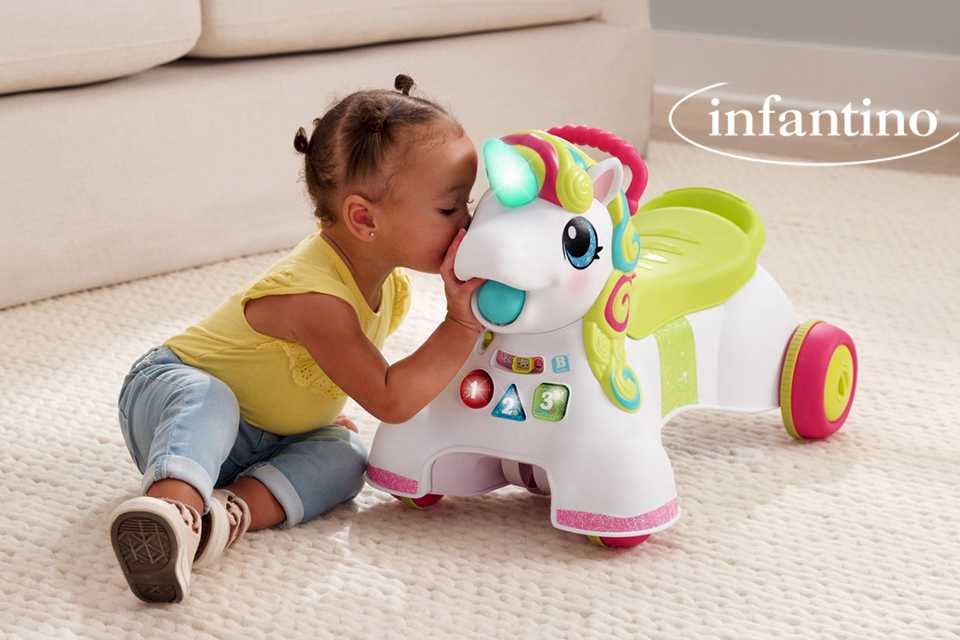 A baby girl playing with an Infantino 3-in-1 sit, walk and ride Unicorn.