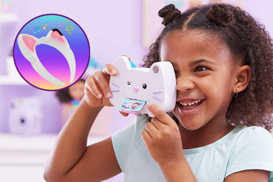 A little girl holding up a Gabby's Dollhouse camera with electronic cat ears on the picture.