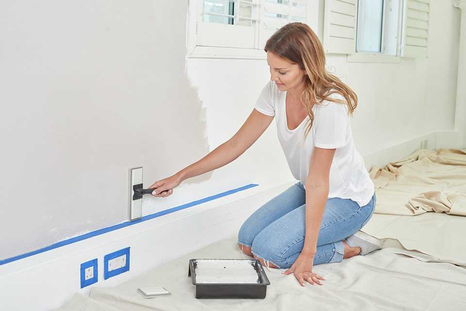 A woman painting a wall.