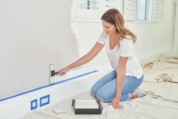 a woman painting a wall