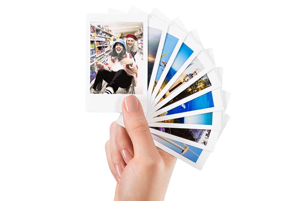 A person holding a bunch of photos printed on instax™ mini film.