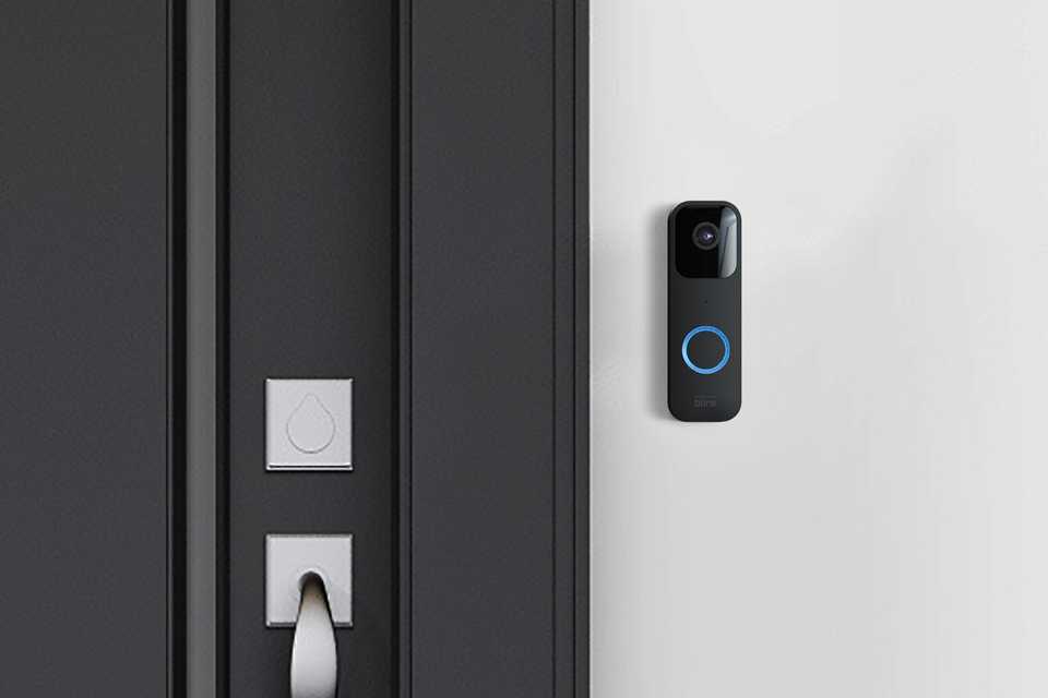 A black Blink video doorbell installed beside the main entrance door.
