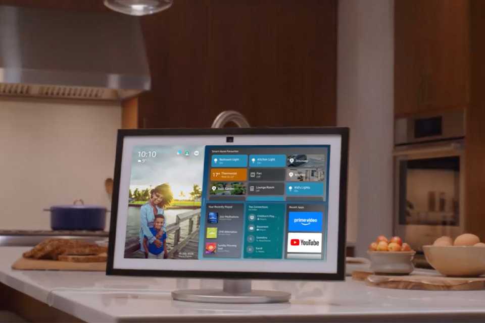 Amazon Echo Show 21 placed on a kitchen countertop with other things.