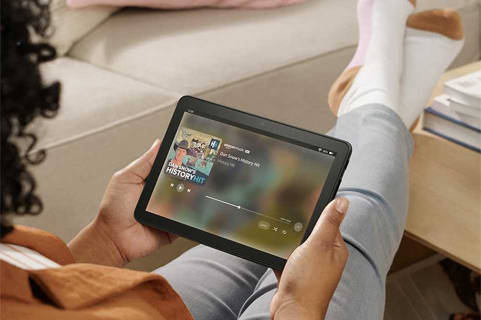 A person streaming content on a black Amazon Fire HD 8 tablet.