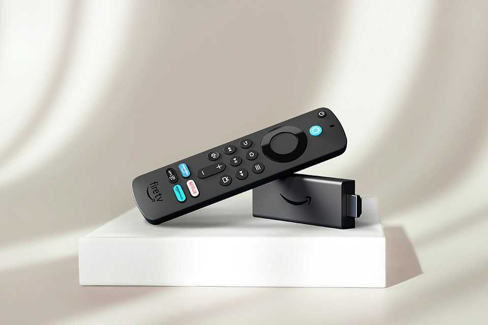 An Amazon Fire TV stick with Alexa and TV guide displayed against a grey background.