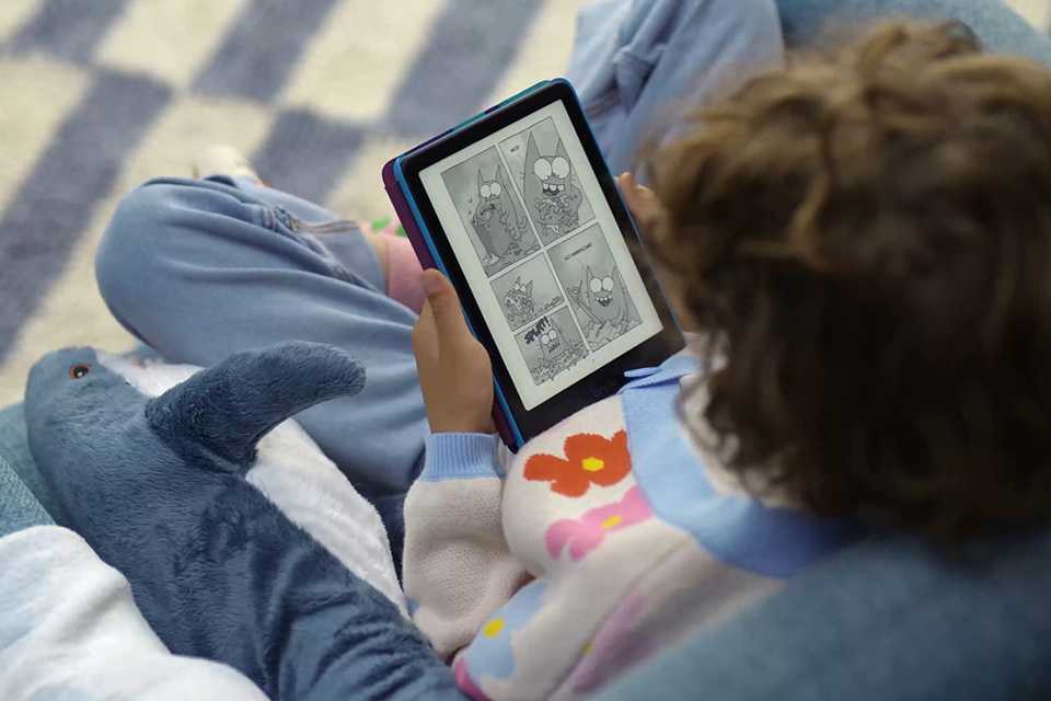 A child reading an e-book on a blue Kindle kids' e-reader.
