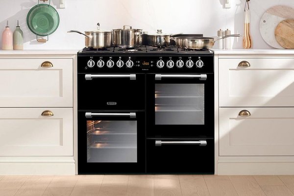 Multiple pots on a dual range cooker in a kitchen.