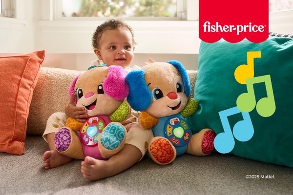 A baby sitting on a couch whilst holding two Fisher Price toys.