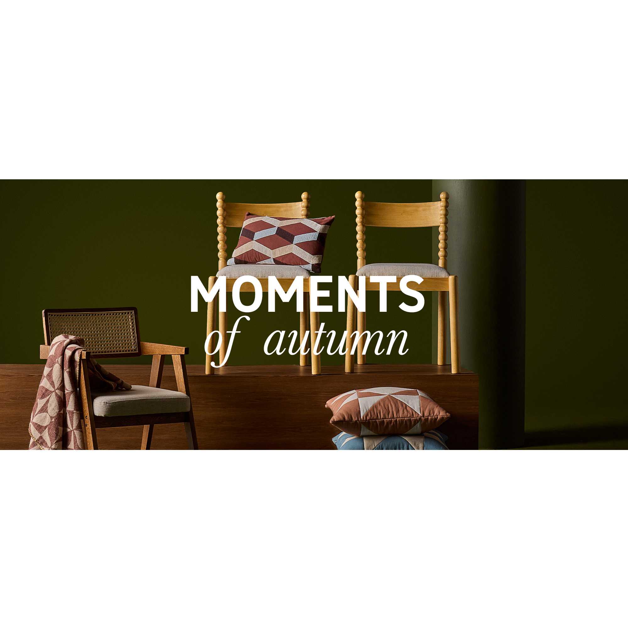 A banner displaying wooden chairs with a cosy throw and patterned cushions on and around them.