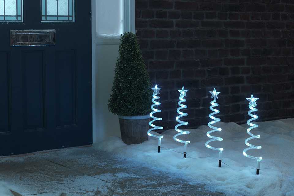 Habitat Pack of 4 Christmas Spiral Tree Path Finder Lights leading to a blue door.