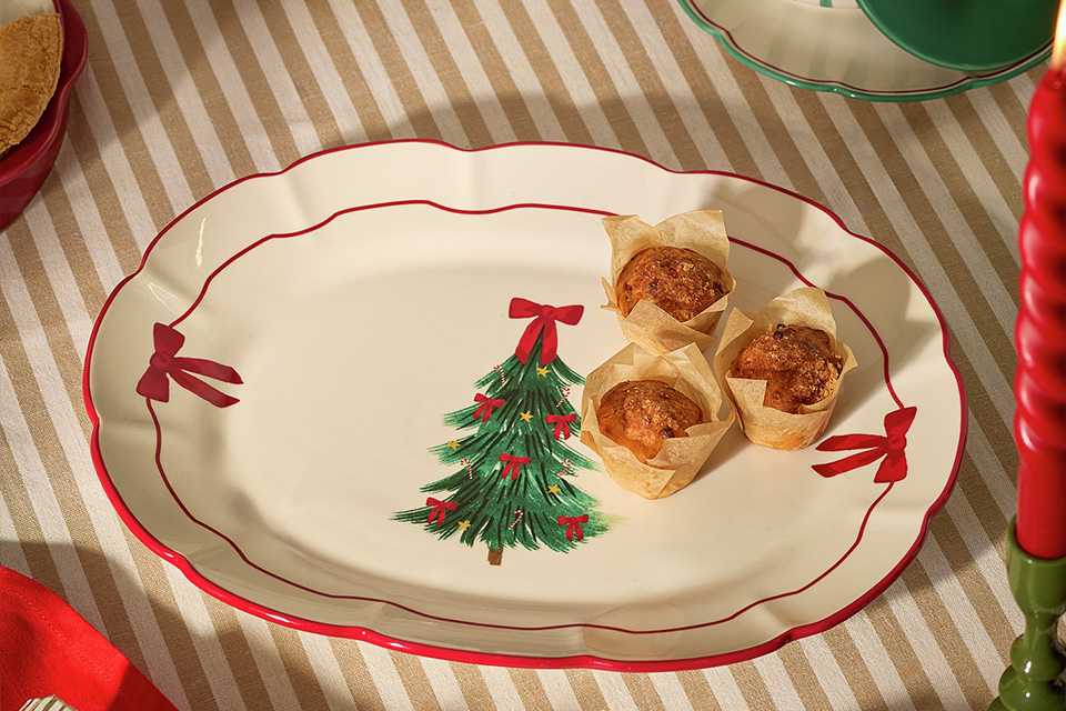 A serving plate with bows on the sides and a bow on a Christmas tress motif.