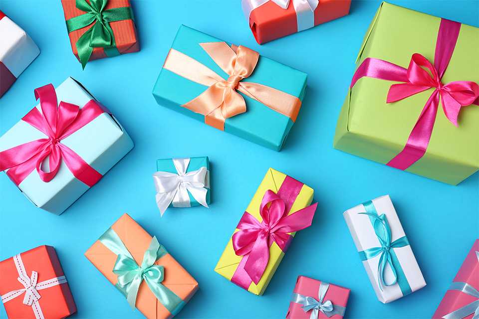 A collection of gift boxes in multiple colours placed on a blue background.