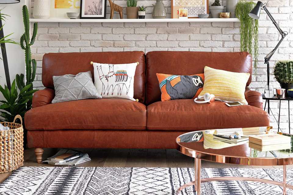 Sofa with cushions, coffee table and rug.
