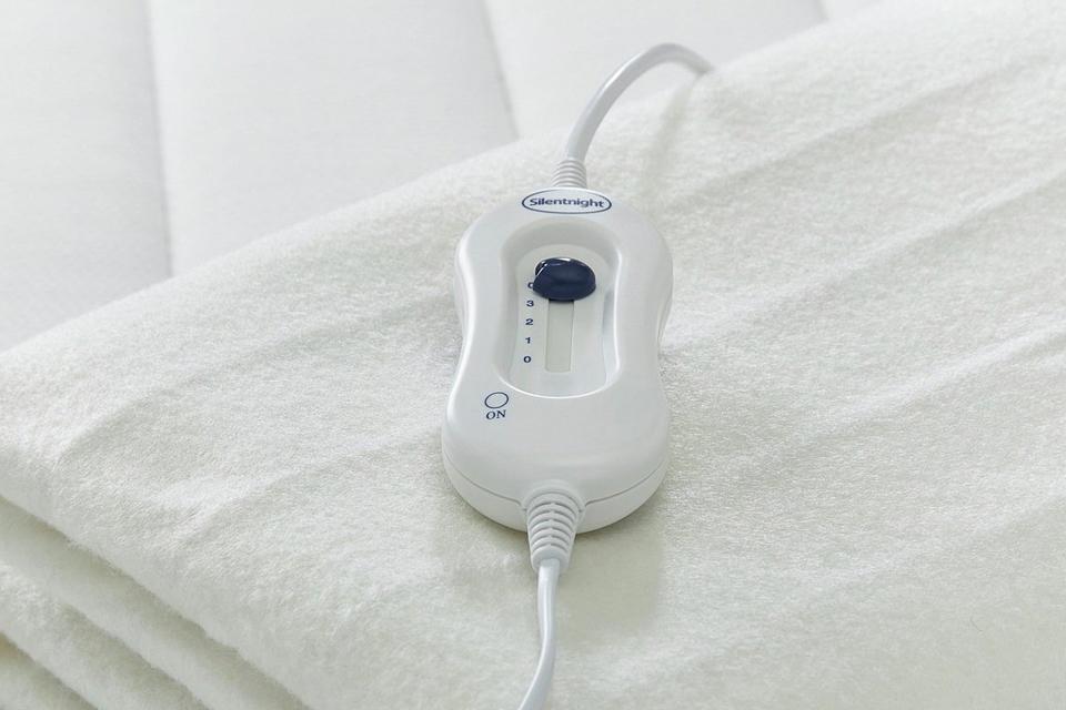 Folded up electric blanket on bed.
