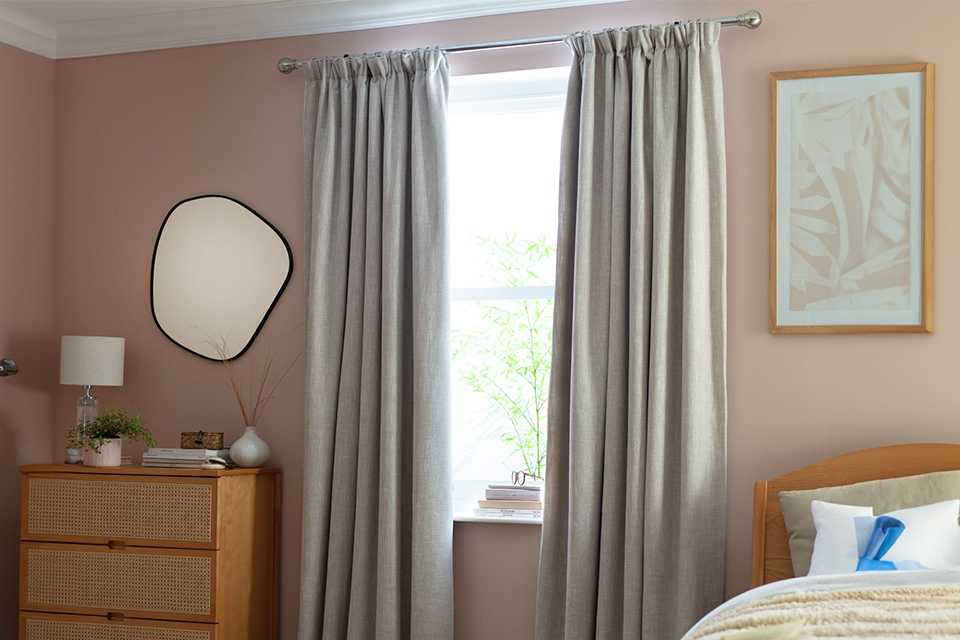 Grey curtains on black curtain pole.