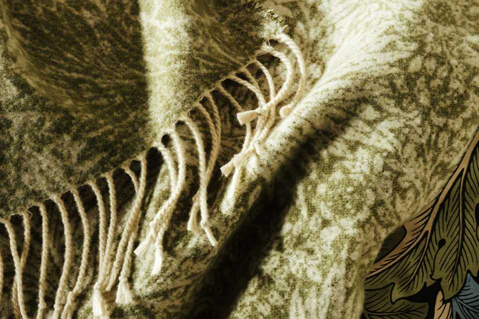 Habitat x Morris & Co collaboration green floral patterened throw with Morris & Co logo.