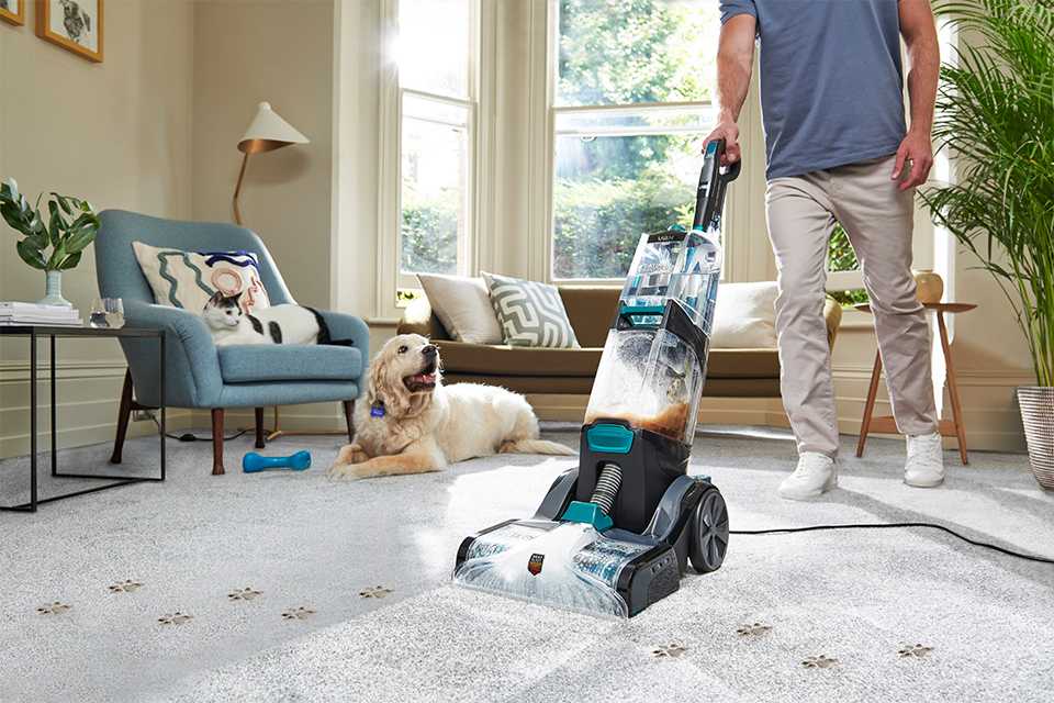 Person using carpet cleaner to clean their home.