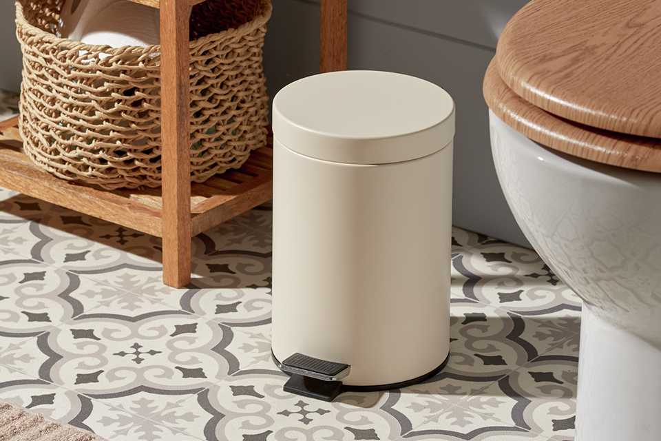Cream bathroom pedal bin beside a vanity unit.