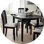An Argos Home black oval dining table with some chairs.