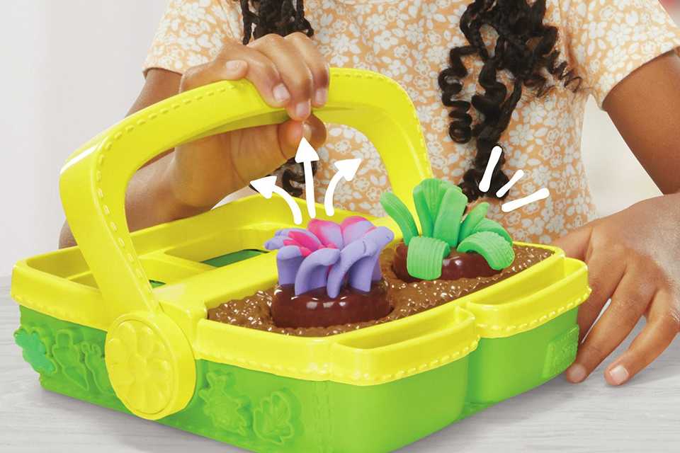 A little girl playing with Play-Doh Blooming Flowers with 5 Tubs & 15 Accessories.