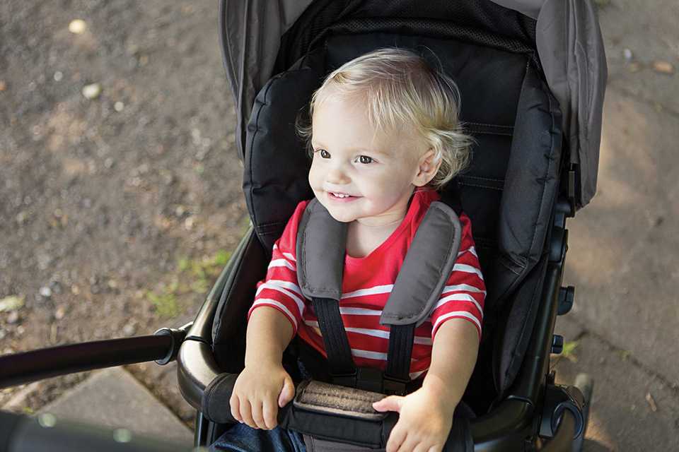 A baby in a Joie Mirus Scenic Reversible Handle Stroller - Ember.
