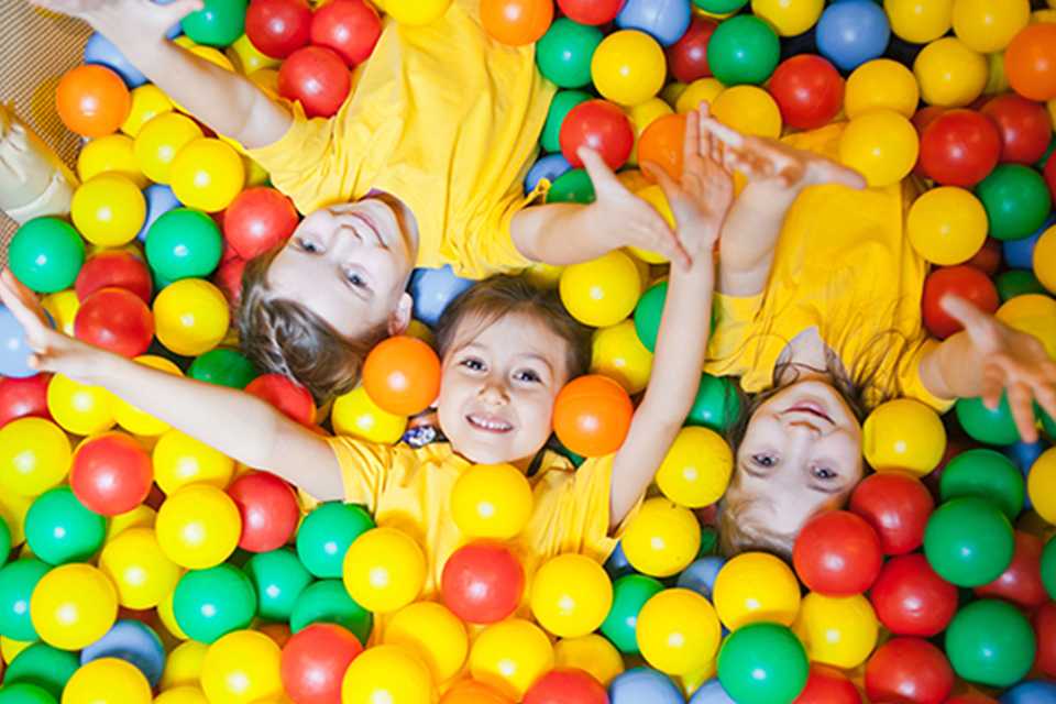 Three children in a ball pit.
