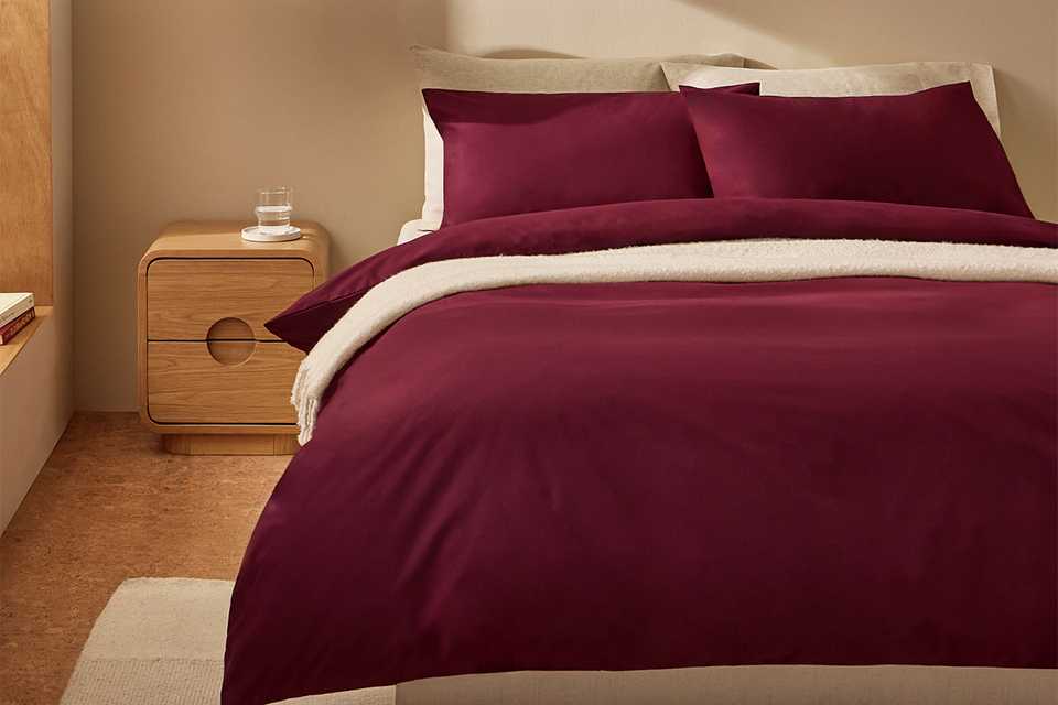 A bed made with a burgundy Habitat cotton king size bedding set.