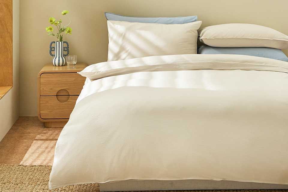 A bed made with a beige Habitat double bedding set.