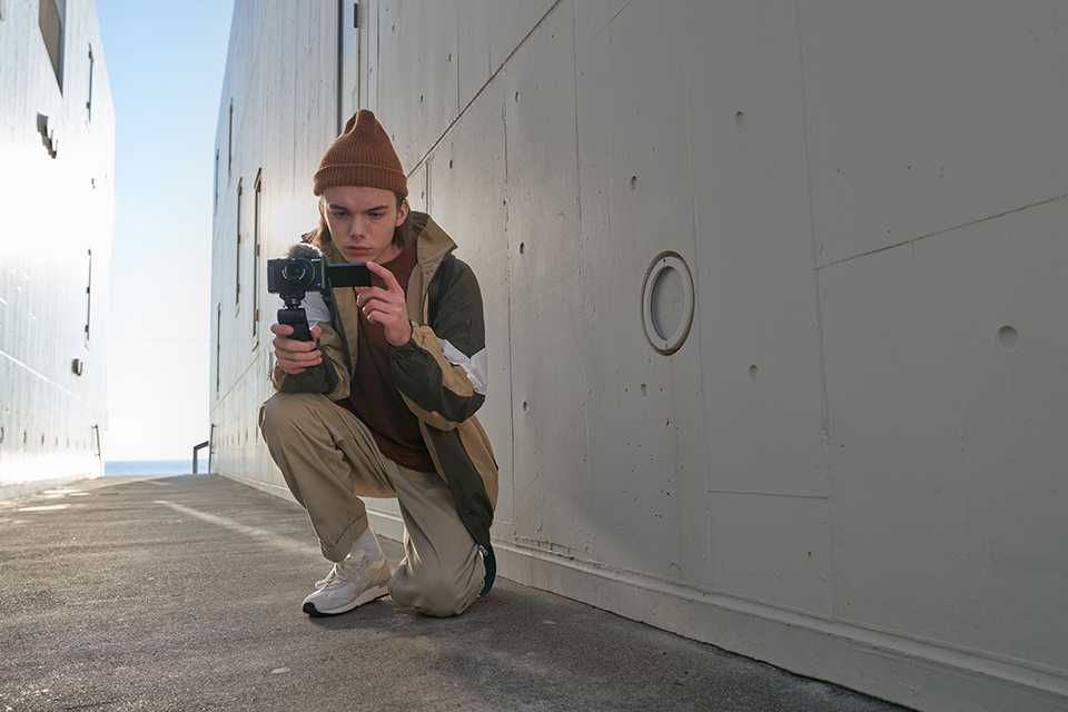 A man holding a Sony vlogging camera.