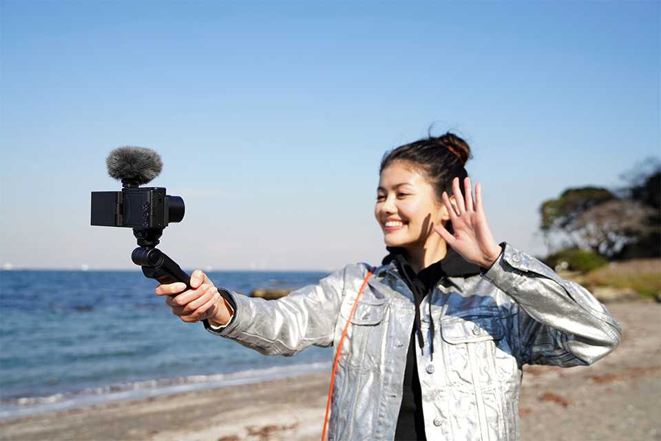 A woman taking a video on a Sony vlogging camera.