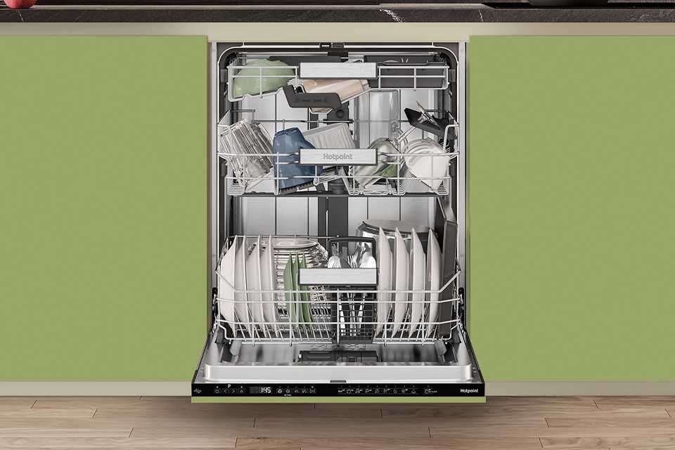 A Hotpoint full size dishwasher seamlessly built into modern green kitchen cabinets.