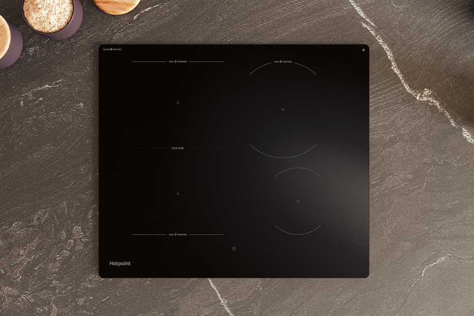 Hotpoint black ceramic hob seamlessly built into modern grey kitchen work surface.