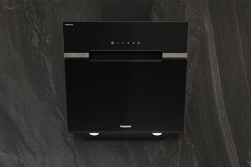 Hotpoint black cooker hood seamlessly built into modern grey kitchen wall.