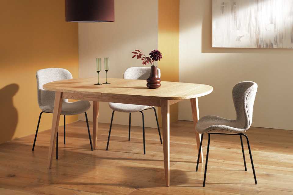 A Habitat extending 6-8 seater dining table with rounded edges in natural wood colour.