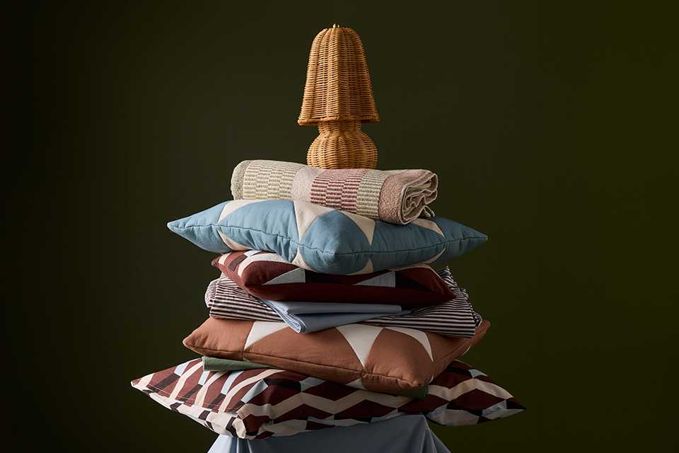 Blue and brown patterned cushions and pillows placed on top of each other.
