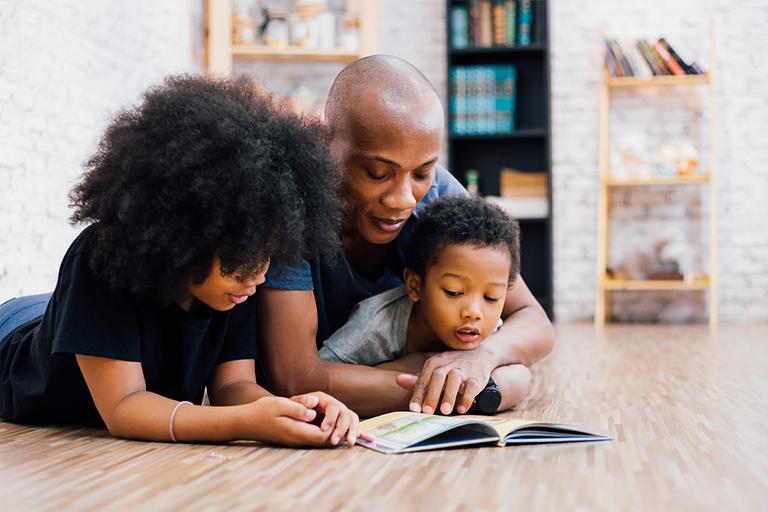Father reading a book with his sons.